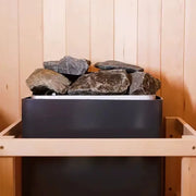 Poêle de sauna avec pierres volcaniques installé dans une cabine en bois