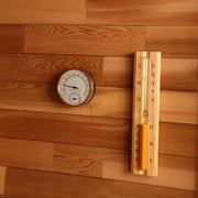 Thermomètre et sablier de sauna fixés sur un mur en bois pour contrôler la température et la durée de séance